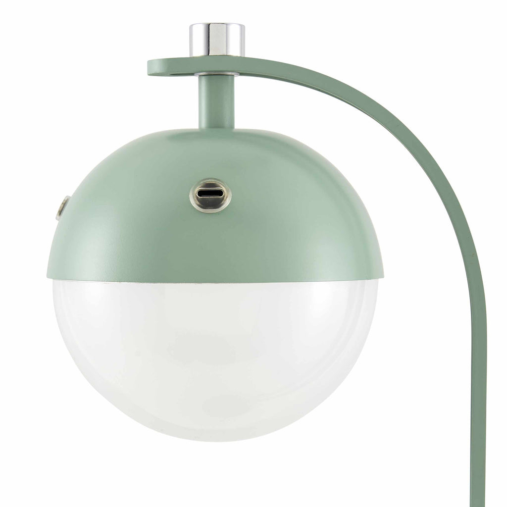 Close-up of traditional table lamp with green exterior and white plastic shade